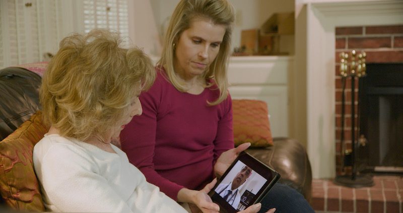Two people using telemedicine on a tablet